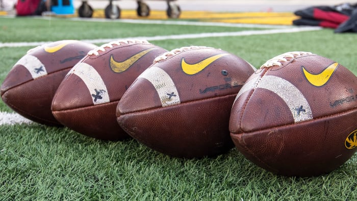 College footballs sit on ground